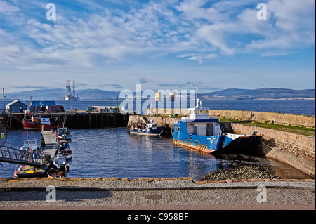 Nigg-Cromarty ferry Cromarty Königin & Fischerboot im Hafen von Cromarty schottischen Black Isle mit Bohranlagen hinter. Stockfoto