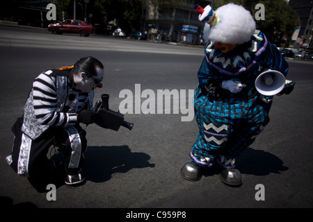 Ein Clown vorgibt, dass er Aufnahme ist, wie er eine gefälschte Kamera aus Pappe während einer Parade in Mexiko-Stadt Stockfoto