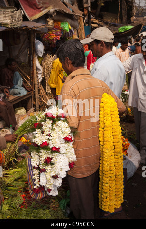 Indien, Kalkutta, Westbengalen, Mullik Ghat, Blumenmarkt, Mann mit Girlanden aus Ringelblumen und Jasmin Stockfoto