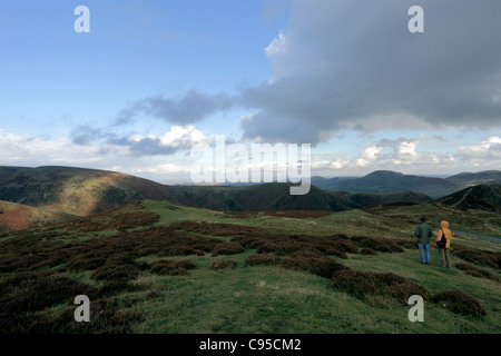 Im Hinblick auf die nordöstlich von oben aus der Longmynd, in der Ferne die Shropshire Hills durch zwei Wanderer gesehen werden. Stockfoto