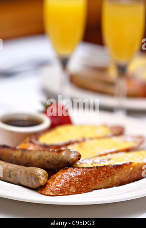 Sonntags-Brunch mit French Toast, geräucherter Applewood, Wurst und Mimosen Stockfoto