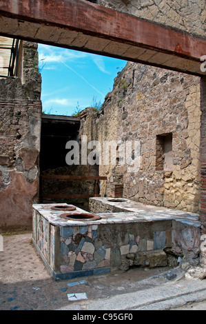 Der Fliesenboden und Zähler mit Tonkrügen (Dolia) eingebettet in ein zweistöckiges ausgegraben Thermopolium, Herculaneum Stockfoto