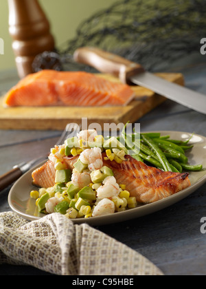 Gegrillter Lachs mit Garnelen und Avocado garniert und serviert mit grünen Bohnen Stockfoto