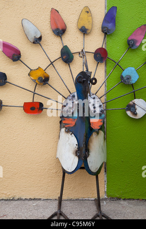 Ein Pfau gefundenen Kunst gemacht von Schrott gegen eine gelbe und grüne Wand Stockfoto