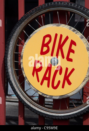 Leuchtend rote und gelbe Bike Rack Zeichen auf einem roten Zaun montiert Stockfoto