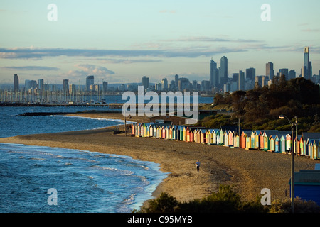 Blick auf Strandhütten am Strand von Brighton mit Skyline der Stadt im Hintergrund.  Melbourne, Victoria, Australien Stockfoto