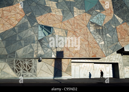 Mann zu Fuß vorbei an der legendären Architektur das Ian Potter Centre, Teil der Federation Square in Melbourne, Victoria, Australia Stockfoto