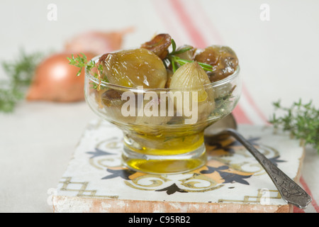 gebackene Zwiebeln in Öl, mit rohen Zwiebeln Hintergrund Stockfoto