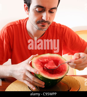 Mann isst ein Stück Wassermelone. Stockfoto