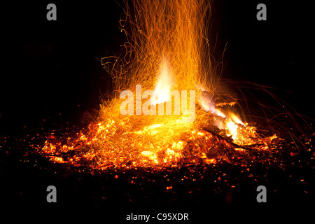 Feuer mit Flammen und Funken. Intensiv orange, gelben Schein der Lagerfeuer vor dem Hintergrund der schwarzen Nacht. Stockfoto