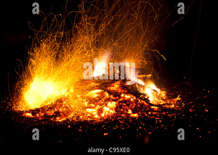 Feuer mit Flammen und Funken. Intensiv orange, gelben Schein der Lagerfeuer vor dem Hintergrund der schwarzen Nacht. Stockfoto