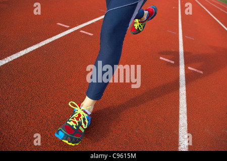 Ausgeführt. Nahaufnahme der Beine einer Frau, die auf einer Leichtathletikbahn. Stockfoto