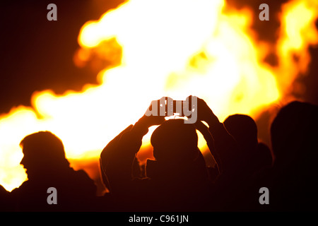 Familien, die Silhouette von Flammen beobachten ein Lagerfeuer auf Guy Fawkes Nacht, Wimbledon Park, London, UK. Foto: Jeff Gilbert Stockfoto