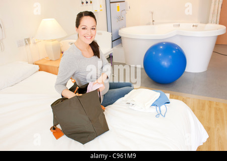 Hausgeburt. Schwangere Frau in ihrem Zimmer bei einer Hausgeburt Auspacken. Stockfoto