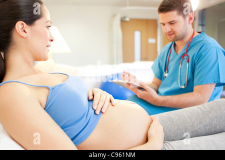 Hausgeburt. Überprüfung auf eine schwangere Frau in einem Raum bei einer Hausgeburt Hebamme. Stockfoto