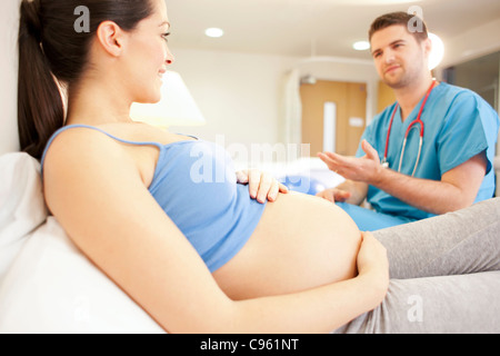 Hausgeburt. Überprüfung auf eine schwangere Frau in einem Raum bei einer Hausgeburt Hebamme. Stockfoto