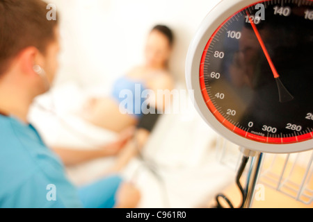 Geburtshilfliche Untersuchung. Eine schwangere Frau Blutdruckmessung bei einer Hausgeburt Hebamme. Stockfoto