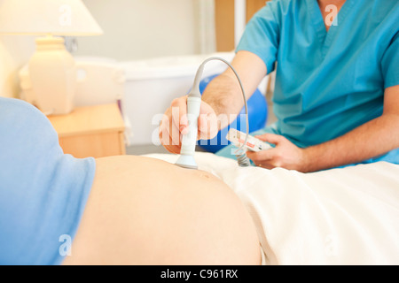 Geburtshilfliche Untersuchung. Mit einem doppler Monitor zum anhören eines Fötus Heartbeart bei einer Hausgeburt Hebamme. Stockfoto