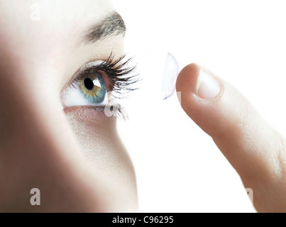 Kontakt-Objektive verwenden. Frau in einer Kontaktlinse weglegen. Stockfoto