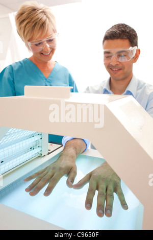 Phototherapie Stand. Patienten mit ihren Händen in einer Phototherapie-Box. Stockfoto
