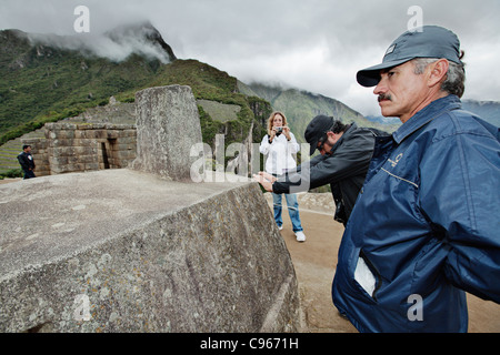 Wachmann beobachtete Intihuatana Steinaltar am alten Inka Ruinen von Machu Picchu, beliebtes Touristenziel in Anden Berge. Stockfoto