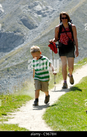 Ein kleiner Junge zu Fuß entlang einer Mountainbike-Strecke mit seiner Mutter Stockfoto