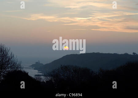 Die Sonne geht aus dem Nebel als Morgendämmerung bricht über die Mumbles-Leuchtturm in der Nähe von Dorf Mumbles, in der Nähe von Swansea, Großbritannien, auf Dienstag, 15. November 2011. Stockfoto