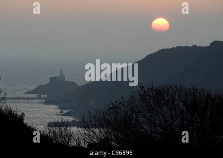 Die Sonne geht aus dem Nebel als Morgendämmerung bricht über die Mumbles-Leuchtturm in der Nähe von Dorf Mumbles, in der Nähe von Swansea, Großbritannien, auf Dienstag, 15. November 2011. Stockfoto