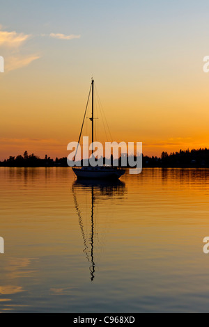 Segelboote verankert in dem ruhigen Wasser des Hafens bei Sonnenuntergang in Grand Marais, Minnesota, USA. Stockfoto