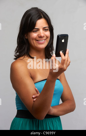 Lächelnde junge Frau hält ein iPhone Stockfoto