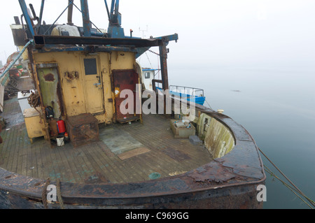 Rostige Fischerboot in einem nebligen Westport Harbour, County Mayo, Irland Stockfoto