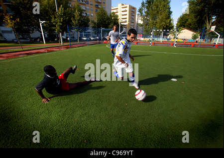 Drei Männer spielen Straßenfußball Stockfoto