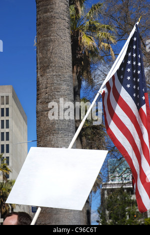 Demonstrant mit Schild mit Exemplar und amerikanische Flagge Stockfoto