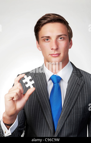 Geschäftsmann, ein Puzzlestück in der hand Stockfoto