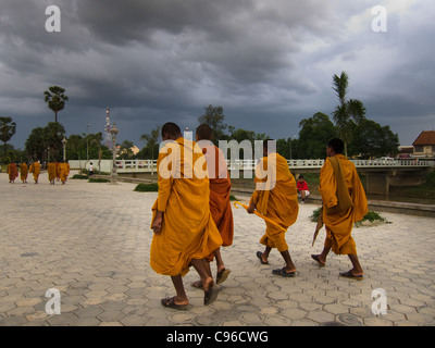 Junge buddhistische Mönche sind Fuß entlang des Flusses in Battambang, es ist Abend und Rush Hour. Stockfoto