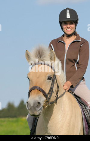 Junge Reiter auf Rückseite des norwegischen Pferd während der Fahrt aus Stockfoto