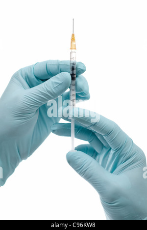 Einrichtungen der medizinischen Behandlung. Vorbereitung für die Injektion. Zwei Hände in Blau Farbe Gummihandschuhe mit Spritze. Stockfoto