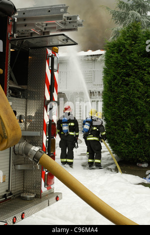 Vancouver Feuerwehr mit Druckluft-Schaum-System, ein Haus in Brand zu löschen. Stockfoto