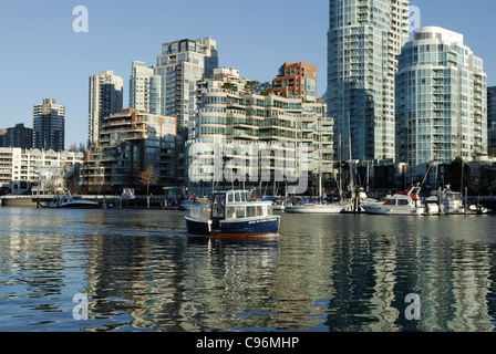 Mit Yaletown im Hintergrund ist ein Wasser-Taxi Richtung Osten auf den Wassern des False Creek, Vancouver. Stockfoto