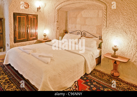 renovierte Höhle Schlafzimmer mit Möbeln und weiße Bettwäsche in einer Tropfsteinhöhle Stockfoto