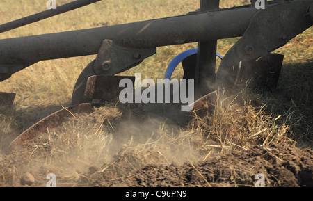 Nahaufnahme Bild der Pflug Schaufeln während des Pflügens in einem trockenen Erde-Feld. Stockfoto