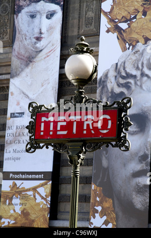 Art Nouveau Metro Zeichen in den Louvre Metro-Station mit Plakaten der Louvre-Ausstellung im Louvre Gebäude Stockfoto