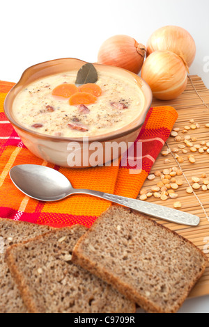 Erbsensuppe, Brot und Zwiebeln auf einem Tisch Stockfoto