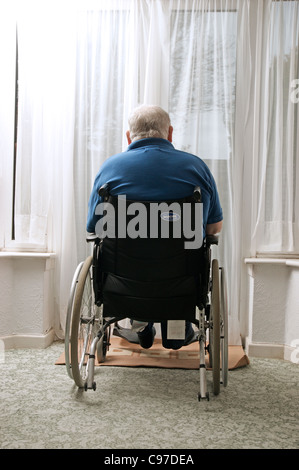 Älteren Mann sitzt im Rollstuhl, Blick aus dem Fenster deaktiviert Stockfoto