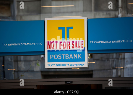TT Hellenic Postbank mit Not For Sale Schild Zeiten wirtschaftlichen Abschwungs in Athen, Griechenland. Stockfoto