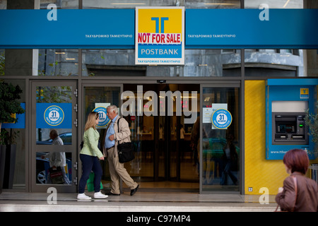 TT Hellenic Postbank mit Not For Sale Schild Zeiten wirtschaftlichen Abschwungs in Athen, Griechenland. Stockfoto