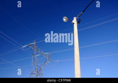 Power-Pylon und Street-Anzeige gegen blauen Himmel Stockfoto