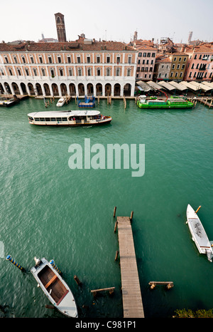 Blick über den Canal Grande in Venedig in Richtung Fischmarkt, mit einem Steg in den Vordergrund und kleine Boote vor Anker. Stockfoto