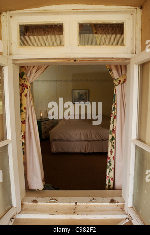 Blick auf Schlafzimmer Innenraum durch ein Fenster aus Holz gerahmt Stockfoto