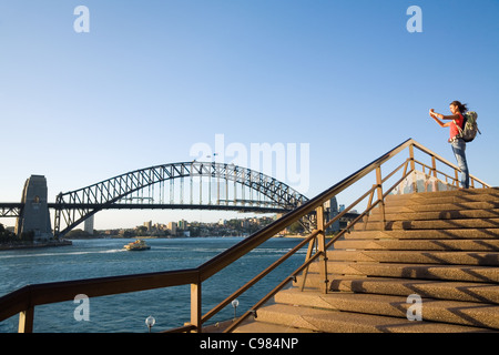 Eine Backpacker fotografiert die Sydney Harbour Bridge von der Treppe des Opernhauses.  Sydney, New South Wales, Australien Stockfoto